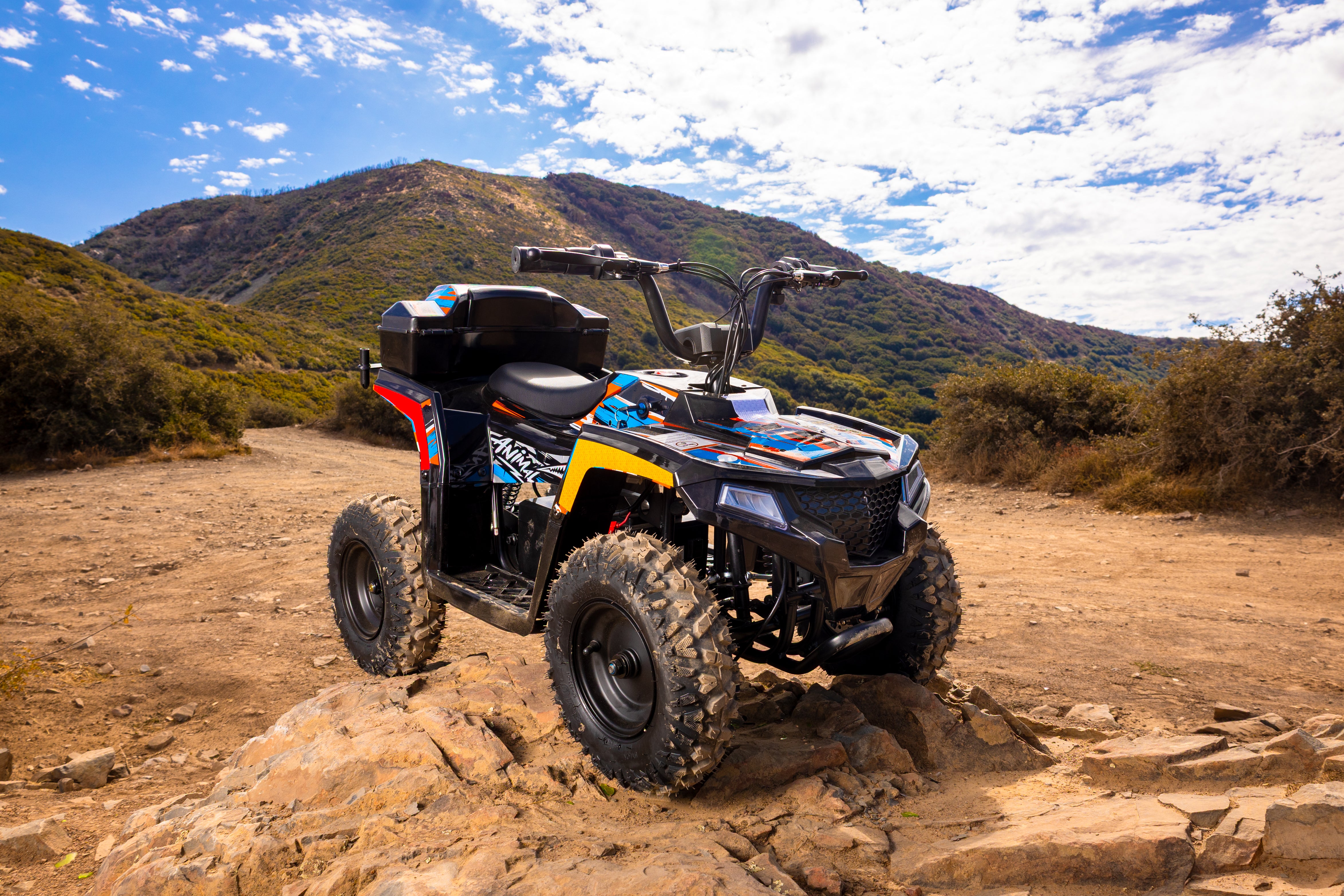 ATV on a dirt trail with mountains in the background